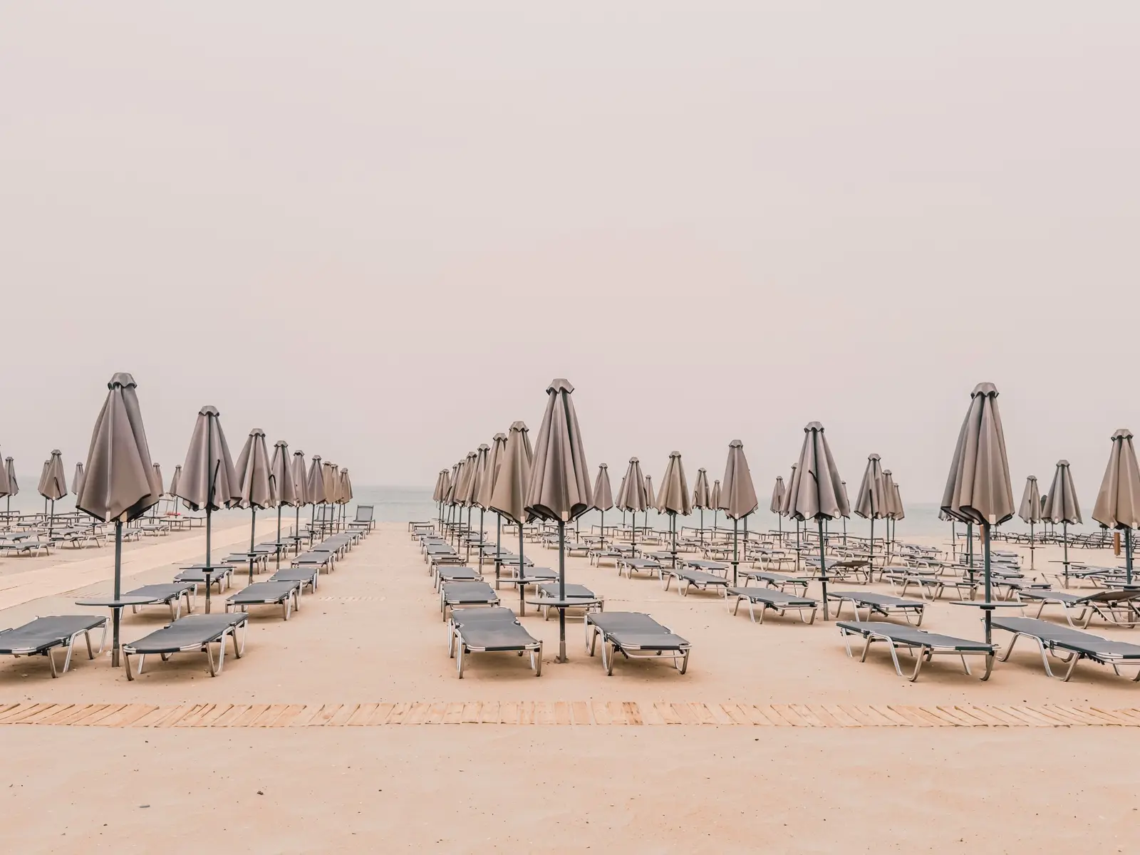 Rows of sunbeds and umbrellas on a quiet beach
