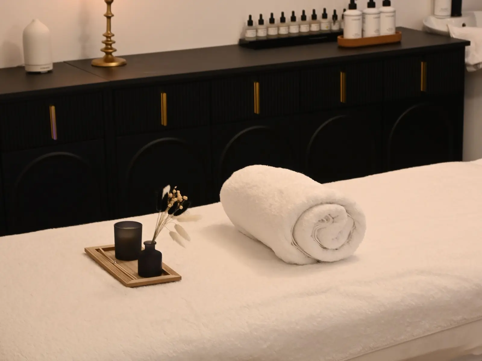A hotel spa treatment room with a massage table and candle