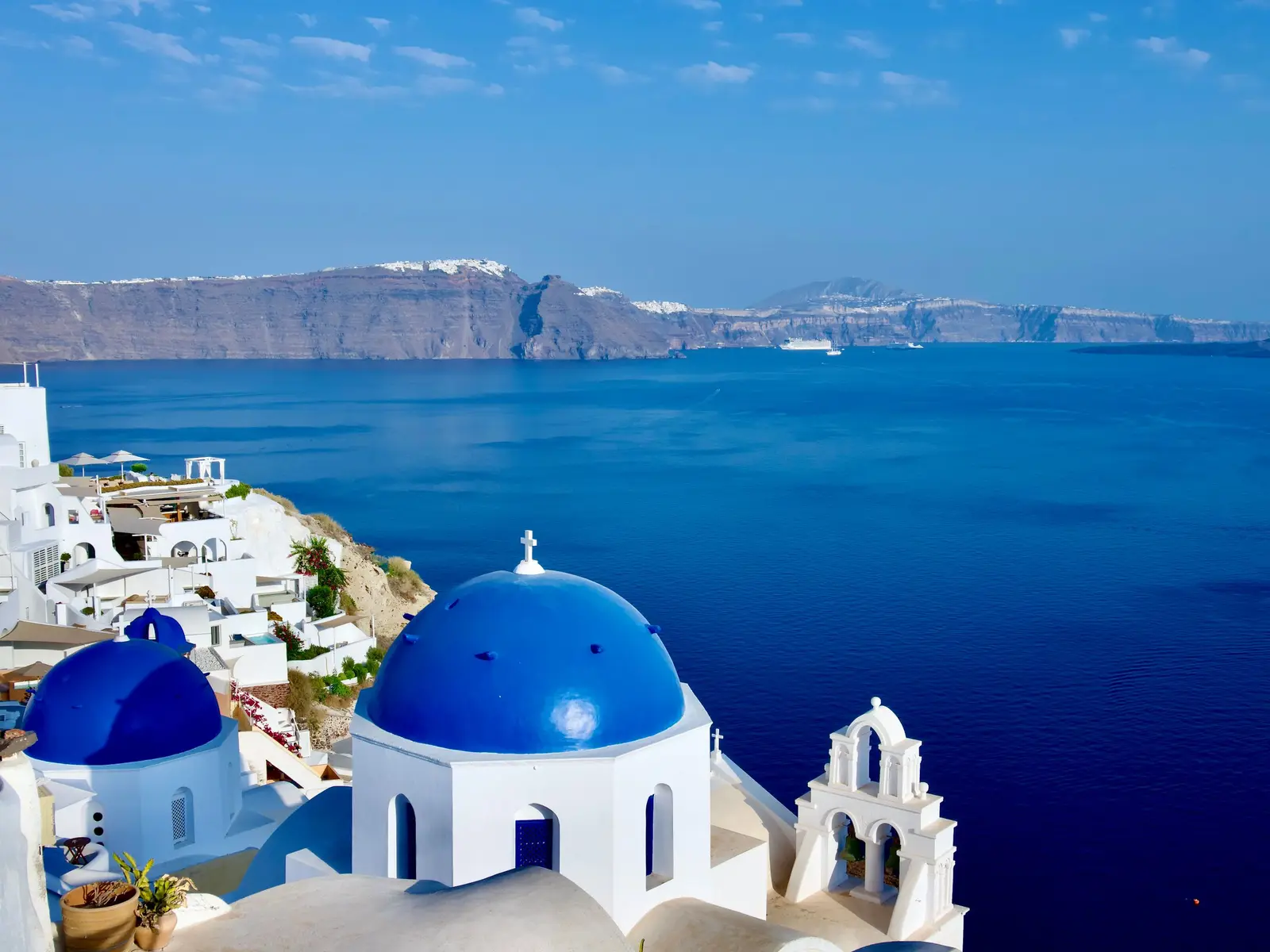 A coastal view of white houses above the blue Aegean